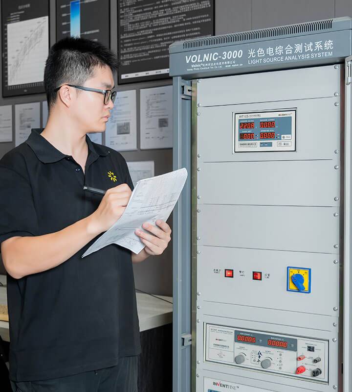 Employees with parameter sheets to record data in the lighting lab